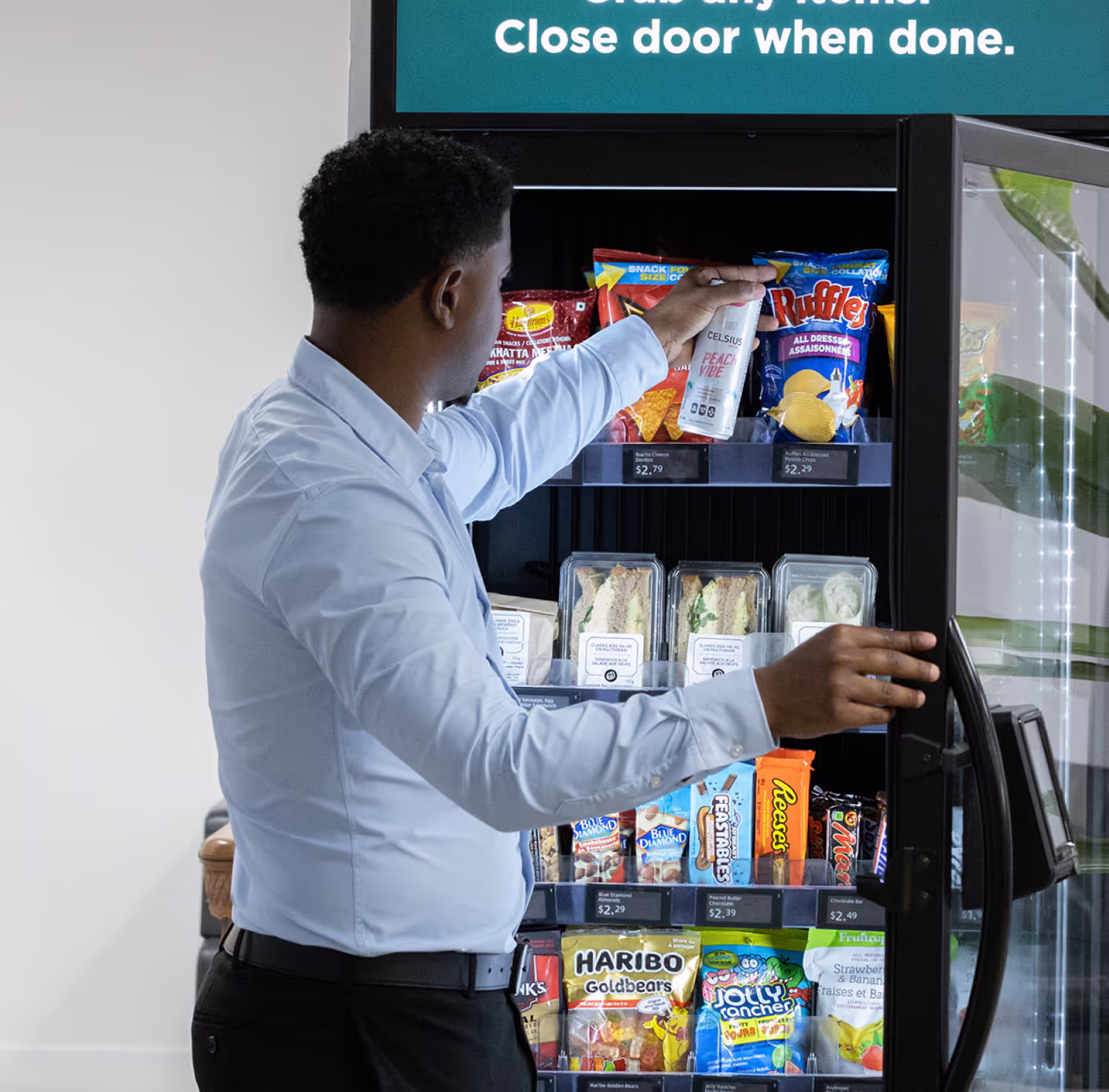 An operator restocking a smart cooler on a vending route.